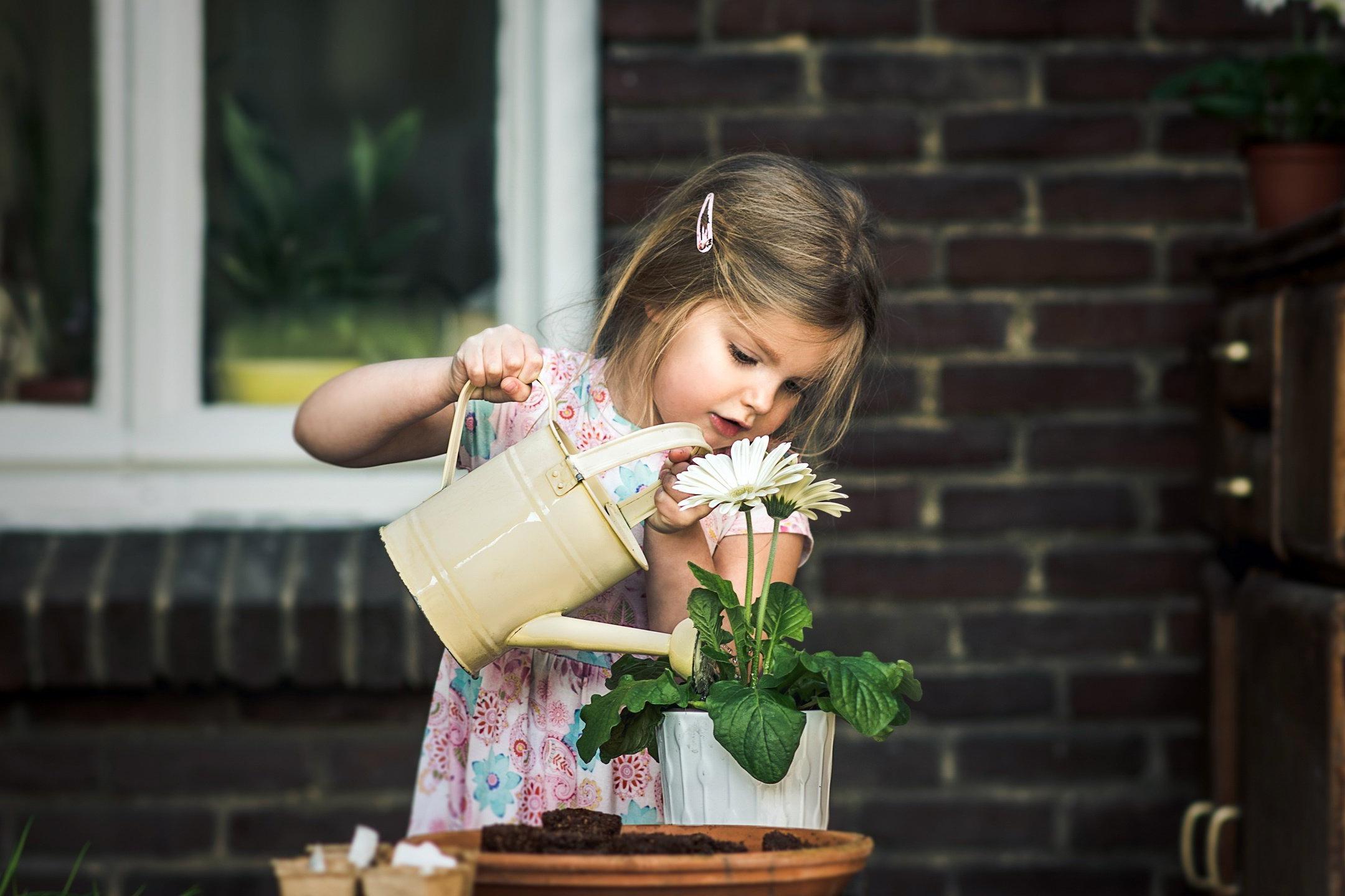 Девочка поливает цветы
