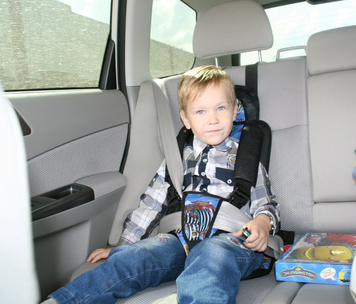 Мальчик в детском кресле в машине