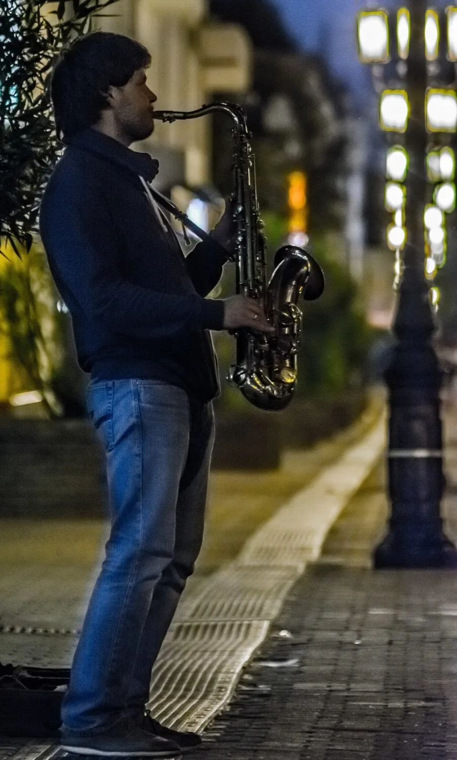 Нижний саксофон. Уличный саксофонист. Саксофонист на улице. Играет на саксофоне на улице.
